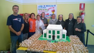 I "vertici" della scuola d'infanzia Sacra Famiglia posano vicino alla torta che riproduce lo storico asilo donata dalla Pasticceria del Pomo di Arese